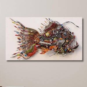 Op de afbeelding: Een kleurrijk visbeeld gemaakt van gerecyclede elektronica en draden. De vis is in profiel afgebeeld, met zijn bek open en zijn vinnen uitgespreid. Het beeld is geplaatst tegen een witte achtergrond.