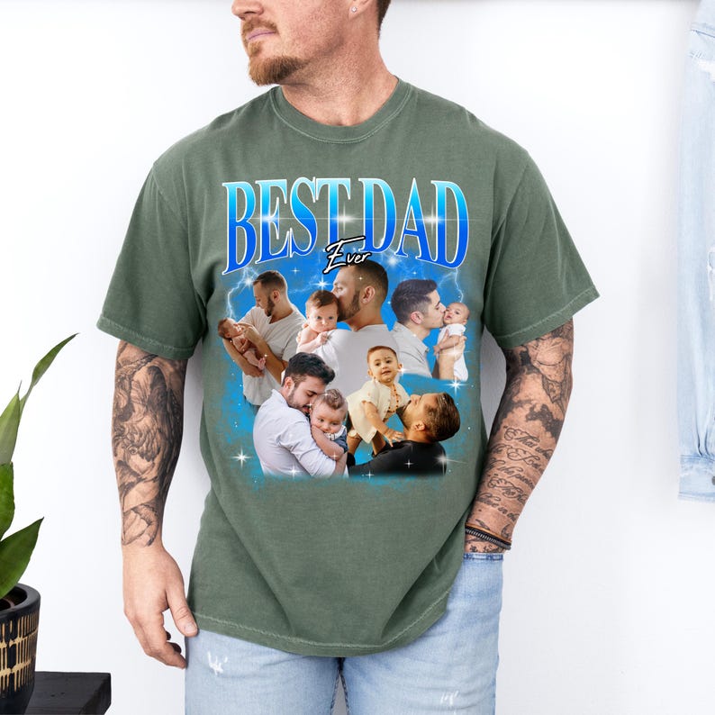 May include: Green t-shirt with the text "BEST DAD Ever" in blue and white. The shirt features a collage of images of a man with babies. The shirt is a solid green color.