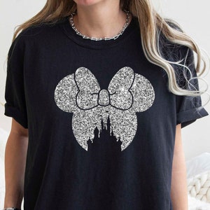 May include: Black t-shirt with a silver glitter design of a bow with a castle inside.