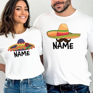 K&ouml;nnte beinhalten: Zwei wei&szlig;e T-Shirts mit einem Sombrero-Motiv und dem Text "NAME". Der Sombrero auf dem linken T-Shirt hat eine rote Blume und der Sombrero auf dem rechten T-Shirt hat einen Schnurrbart.