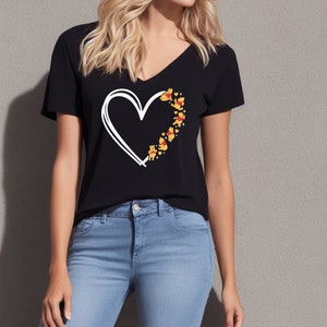 May include: A black t-shirt with a white outline of a heart.  The heart is filled with small yellow cartoon bears.