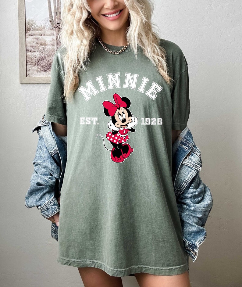 May include: A green t-shirt with a white graphic of Minnie Mouse and the text "MINNIE EST. 1928".
