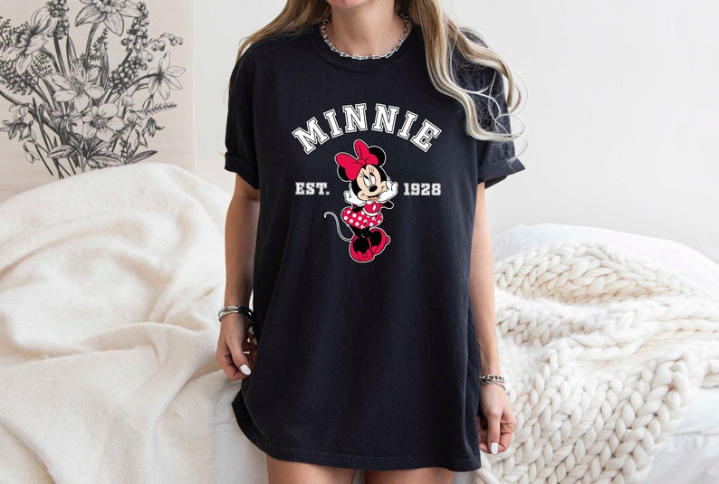 May include: Black t-shirt with a white graphic of Minnie Mouse and the text "Minnie Est. 1928".