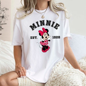 May include: White t-shirt with a black graphic of Minnie Mouse and the text "Minnie Est. 1928".