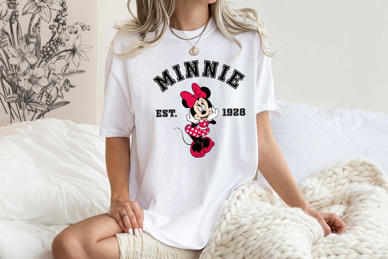 May include: White t-shirt with a black graphic of Minnie Mouse and the text "Minnie Est. 1928".