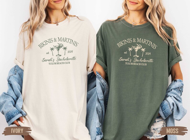 May include: Two oversized t-shirts with a vintage-inspired design. The shirts are in ivory and moss green colors. The design features a martini glass with a lime wedge, palm trees, and the text "Bikinis & Martinis est 2024 Sarah's Bachelorette Tulum Beach Club".