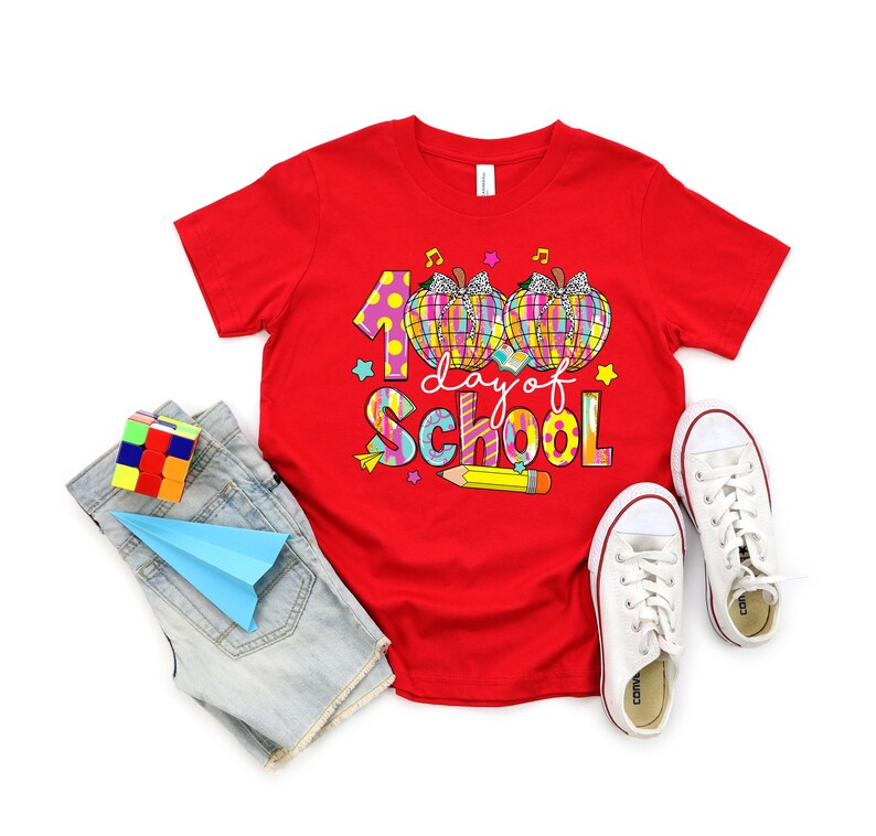 May include: Red t-shirt with a colorful graphic of two pumpkins and the text "100 days of school".