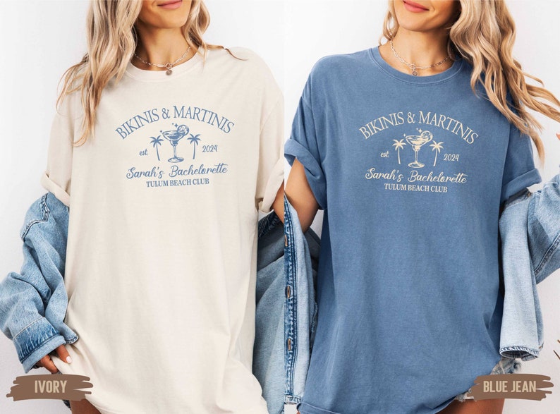 May include: Two t-shirts, one ivory and one blue jean, with the text "Bikinis & Martinis est 2024 Sarah's Bachelorette Tulum Beach Club" printed on the front.