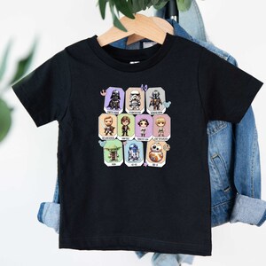 May include: Black short-sleeved t-shirt with a colorful graphic of Star Wars characters. The characters are in a grid pattern with their names below each character.