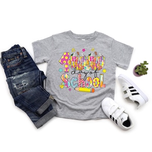 May include: A gray t-shirt with a colorful graphic that says "100 day of school" with two pumpkins and a pencil.
