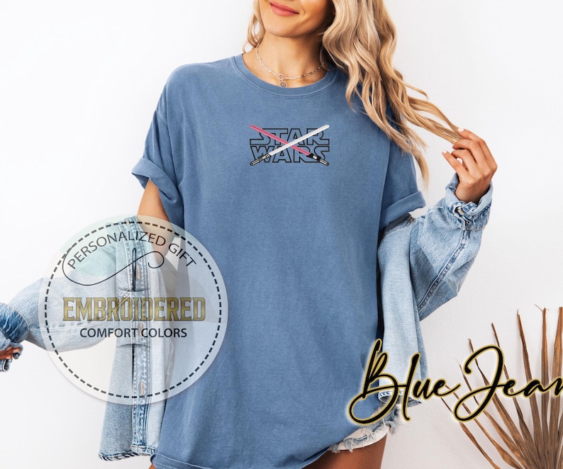 May include: A blue t-shirt featuring the text "STAR WARS" and a graphic of two crossed lightsabers.