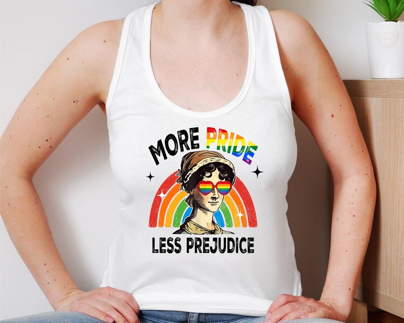 May include: White tank top with a rainbow and the text "More Pride Less Prejudice". A woman with rainbow heart-shaped sunglasses is in the centre of the rainbow.