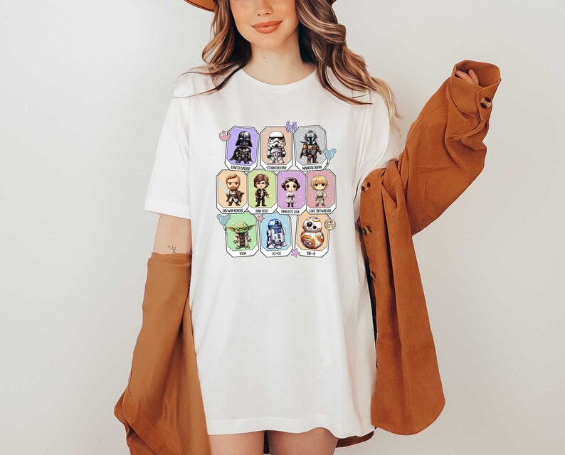 May include: White t-shirt with a colorful graphic of Star Wars characters. The characters are in a grid pattern and include Darth Vader, Stormtrooper, Yoda, R2-D2, and others.