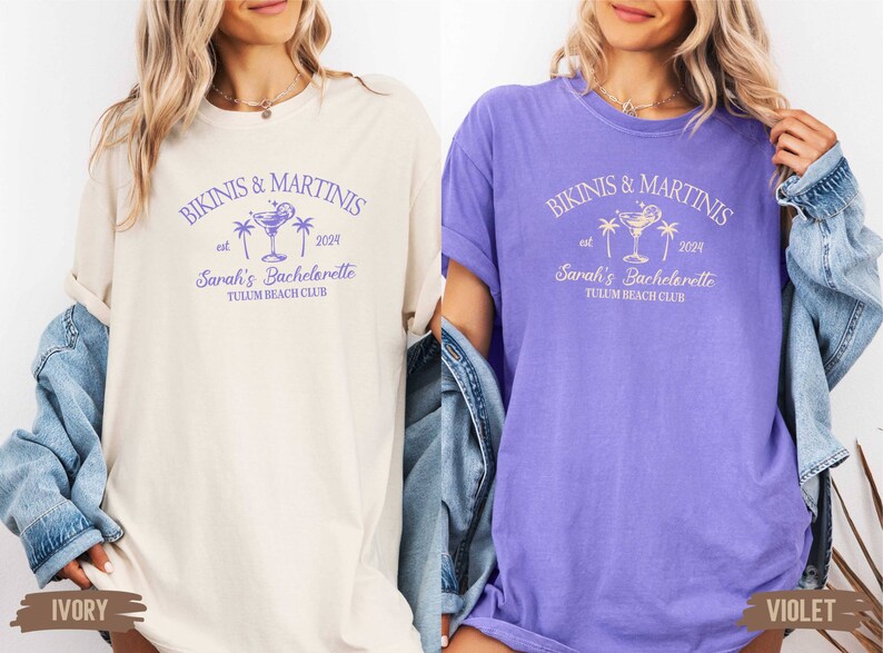 May include: Two t-shirts in ivory and violet with the text "Bikinis & Martinis est. 2024 Sarah's Bachelorette Tulum Beach Club" and a graphic of a cocktail glass with a lime and palm trees.