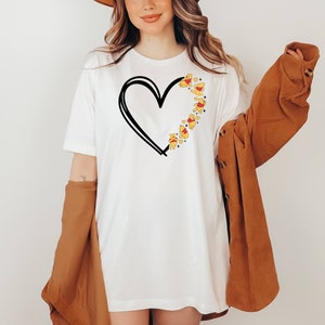 May include: White t-shirt with a black outline of a heart and Winnie the Pooh characters forming the heart shape.