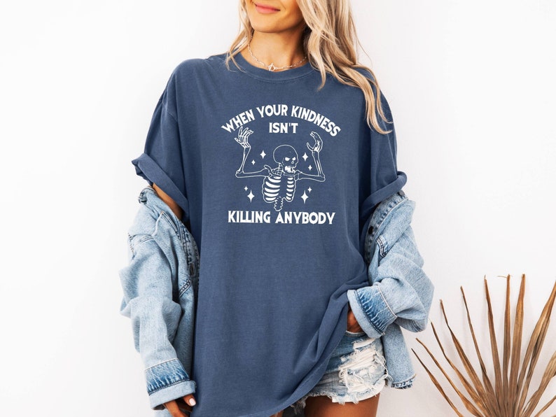 May include: A navy blue t-shirt with a white skeleton graphic and the text "When your kindness isn't killing anybody".
