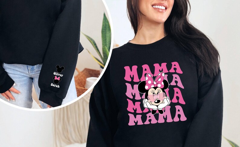 Puede incluir: Sudadera negra con un gr&aacute;fico rosa de Minnie Mouse y el texto "MAMA" repetido cuatro veces. La sudadera tiene cuello redondo y mangas largas.