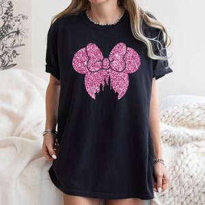 May include: Black t-shirt with a pink glitter bow and castle design.