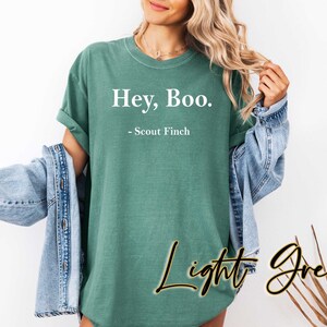 May include: A light green t-shirt with the text "Hey, Boo. - Scout Finch" printed in white.
