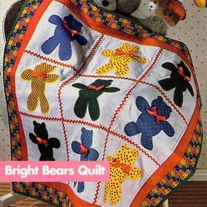 May include: A patchwork quilt with bear appliqués in blue, yellow, green, and black, each with a bow. The quilt has a decorative border and the text "Bright Bears Quilt". The design is suitable for a nursery or child's room.