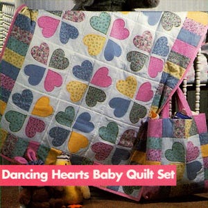 May include: A baby quilt set featuring a quilt and matching tote bag. The quilt is white with colorful heart patterns in pink, blue, yellow, and green. The tote bag has a similar design. The text "Dancing Hearts Baby Quilt Set" is visible.