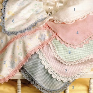 May include: A collection of baby blankets in various colors and patterns. The blankets feature crochet lace edging in white, pink, and blue. Some blankets have handprint and heart patterns.