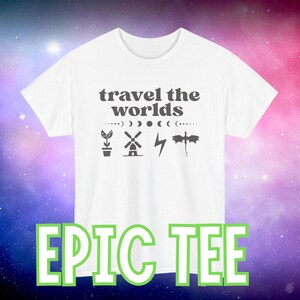 Op de afbeelding: Wit t-shirt met de tekst "travel the worlds" en diverse grafische iconen, waaronder een plant, een windmolen, een bliksemschicht en een draak. Het shirt heeft ook de tekst "EPIC TEE" in groene letters.