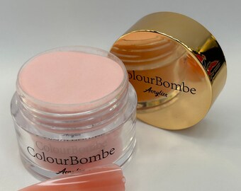 Puede incluir: Un tarro de polvo acrílico rosa con la etiqueta "ColourBombe Acrylics".
