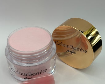 Puede incluir: Un polvo acrílico rosa en un frasco transparente con tapa dorada. El frasco está etiquetado con "ColourBombe Acrylics". También se muestra una punta de uña acrílica rosa.