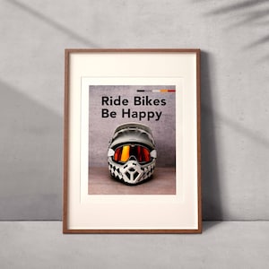 Könnte beinhalten: Ein gerahmter Druck mit dem Text "Ride Bikes Be Happy" und einem schwarz-weißen Motocross-Helm mit orange getönten Brillen.