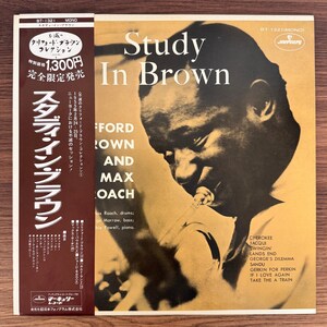 May include: A vinyl record cover titled Study In Brown by Clifford Brown and Max Roach. The cover features a sepia-toned photograph of a musician playing a trumpet, with white text listing the artists and track titles. A dark brown obi strip is attached.