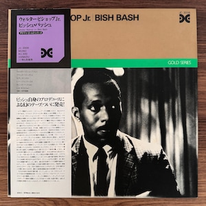 Puede incluir: Portada del álbum "OP Jr. BISH BASH" de Walter Bishop Jr. Presenta un retrato en blanco y negro de un hombre con traje. La portada incluye texto en japonés e inglés, con una combinación de colores púrpura y dorado.