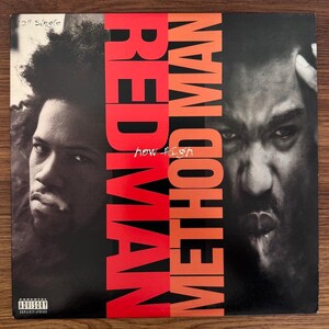 May include: A 12-inch vinyl record cover featuring black and white portraits of two individuals. The text REDMAN and METHOD MAN is printed in large, bold red letters vertically down the center, with the words how high in white script.