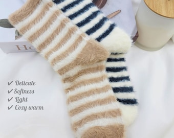 May include: A pair of fuzzy striped socks, one with brown and white stripes and the other with black and white stripes. The socks are soft and cozy, perfect for keeping your feet warm in the winter.