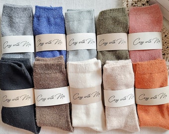 May include: Ten pairs of cozy socks in various colors, including gray, blue, green, pink, orange, brown, and white. Each sock has a label that reads "Cozy with Me".