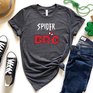 Puede incluir: Camiseta gris con un gr&aacute;fico de Spider-Man y el texto "SPIDER BRO" en negro y rojo.