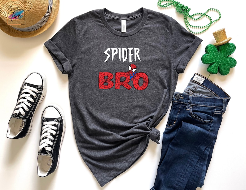 Puede incluir: Camiseta gris con un gr&aacute;fico de Spider-Man y el texto "SPIDER BRO" en negro y rojo.