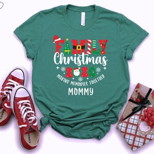 May include: A teal t-shirt with the text "Family Christmas 2020 Making Memories Together Mommy" in red, white, and green. Red trainers and wrapped gifts with red bows are also in the image.