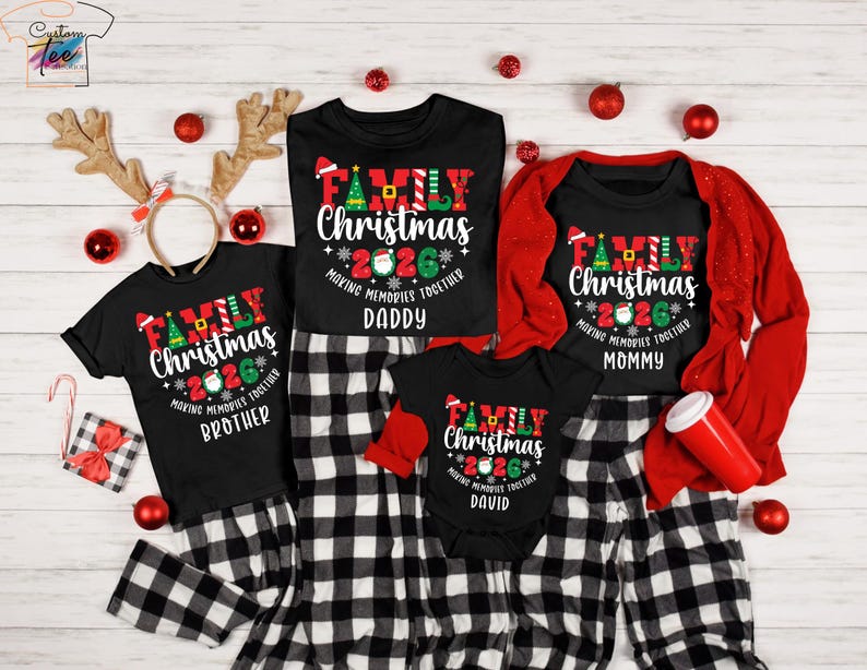May include: A set of black Christmas family pyjamas, each with "Family Christmas 2026" printed on them. The pyjamas are for "Brother", "Daddy", "Mommy", and "David". The image includes red accessories and reindeer antlers for a festive look.
