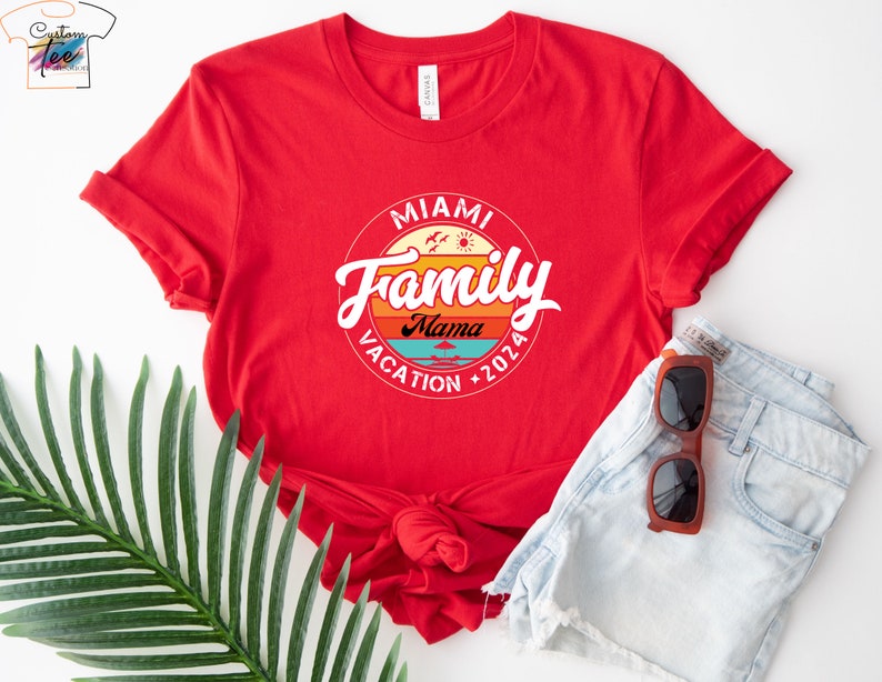 May include: Red t-shirt with a white circle graphic that says "Miami Family Vacation 2026" with a sunset design and the word "Mama" in the center.