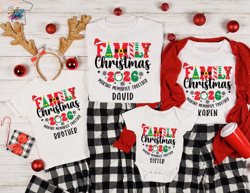 May include: A set of white Christmas tops and a babygrow, each with "FAMILY Christmas 2026" in red, green, and black. They are displayed with black and white checked pyjama bottoms. Christmas decorations are scattered around.