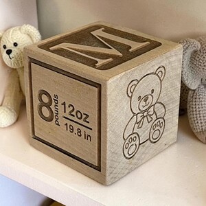 Personalized wooden baby block showing birth weight, length, child’s name, and custom engraved image