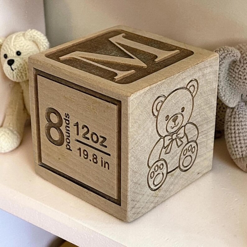 Personalized wooden baby block showing birth weight, length, child’s name, and custom engraved image