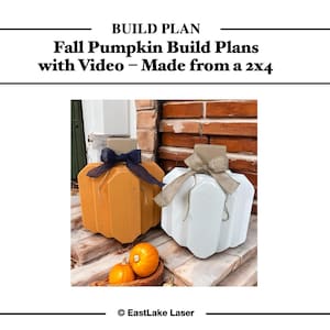 May include: Two wooden pumpkin decorations, one orange and one white, with burlap and navy blue bows. The pumpkins are displayed on a wooden surface with two real pumpkins in a basket. The text reads "Fall Pumpkin Build Plans with Video - Made from a 2x4".