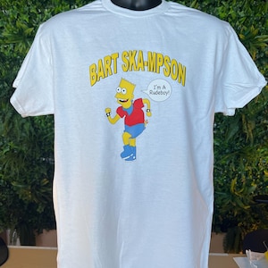 May include: White t-shirt featuring a cartoon image of Bart Simpson in a red shirt and blue shorts, with the text "BART SKA-MPSON" in yellow. A speech bubble says "I'm A Rudeboy!"