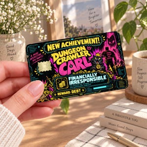 May include: A rectangular credit card skin featuring a vibrant Dungeon Crawler Carl design with neon pink and yellow graphics, a black cat, and text reading New Achievement, Financially Irresponsible, and Reward: Debt on a dark background.