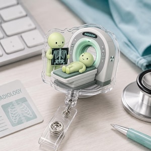 Może przedstawiać: Przezroczysty identyfikator akrylowy z motywem radiologicznym w stylu kreskówkowym, przedstawiający jasnozieloną postać trzymającą zdjęcie rentgenowskie oraz drugą jasnozieloną postać leżącą na skanerze CT z napisem RADIOLOGY.