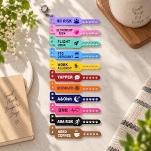 May include: A vertical stack of eleven colorful silicone wristbands attached to a metal keyring. Each band features unique text and icons: HR RISK, ELOPEMENT RISK, FLIGHT RISK, PTO DEFICIENT, WORK ALLERGY, YAPPER, OVERSTIMULATED, A&Oish, DNR, AMA RISK, and NEED COFFEE.