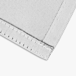 May include: Close-up of a light gray textile with a diagonal weave pattern. The edge is folded over and stitched with white thread, creating a clean, finished corner. The fabric has a subtle texture.