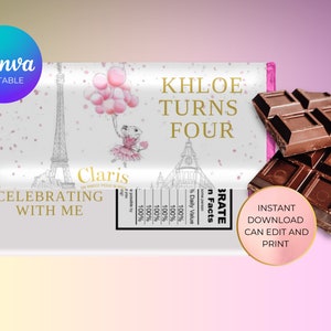 Peut inclure: Une enveloppe de chocolat blanc avec une bordure rose. L'enveloppe présente un dessin de la tour Eiffel, une fille en tutu rose tenant des ballons et le texte "Khloe Turns Four" en lettres dorées. Le texte "Celebrating with me" est également inclus en lettres dorées. L'enveloppe est conçue pour une fête d'anniversaire.
